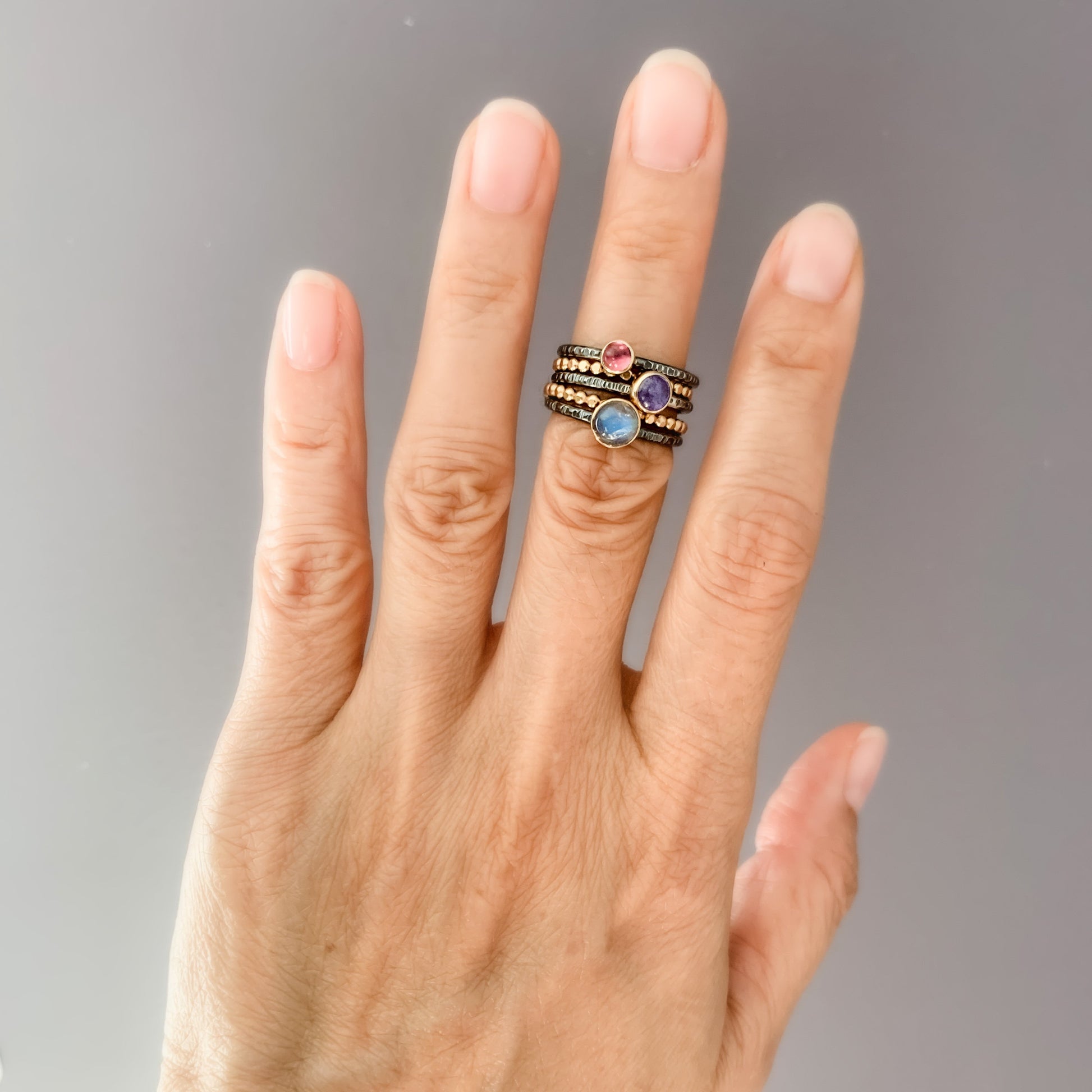 Gold and Oxidized gemstone stacking rings with Tourmaline, moonstone, and tazanite